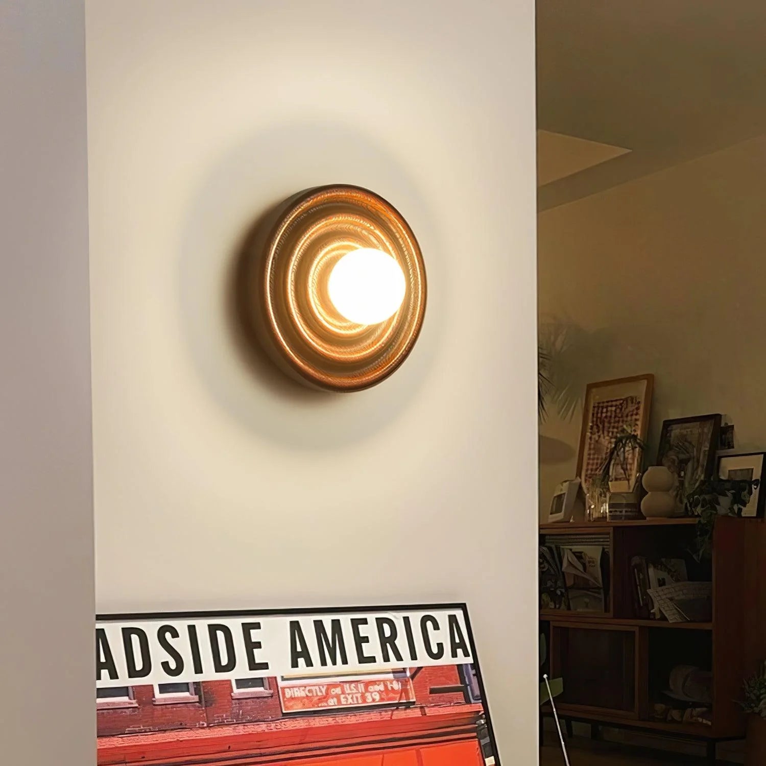 Zenviae Grove Wall Lamp mounted on white wall above poster