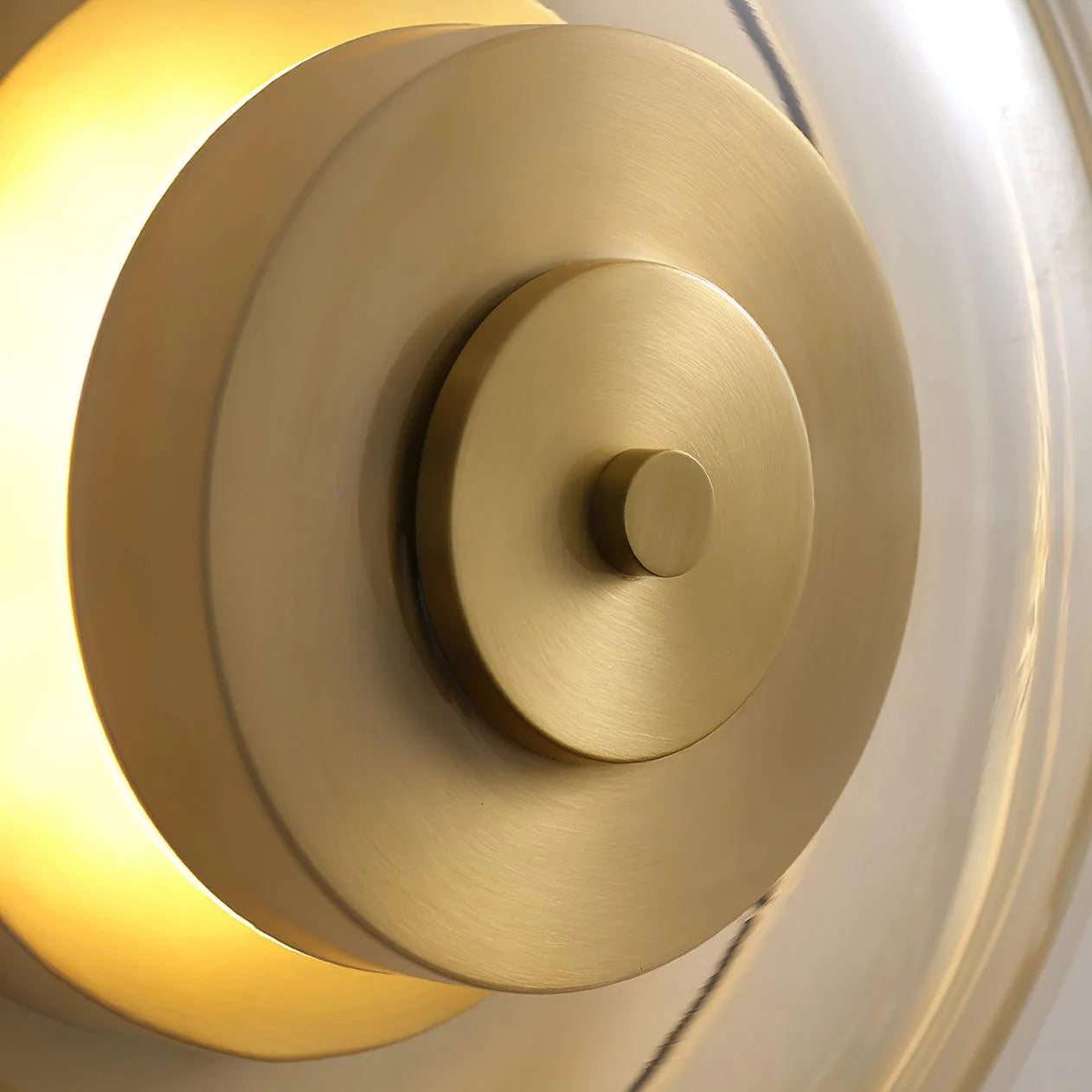 Zenviae Orbit Glow Wall Lamp detail of golden center and clear glass ring